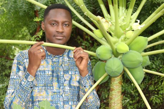 Souleymane Tamponé tenant une branche de papayer / Crédit photo : Be Proud