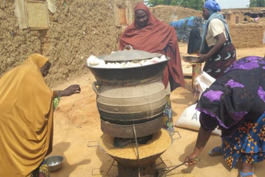 Des femmes préparant sur un four à balle de riz