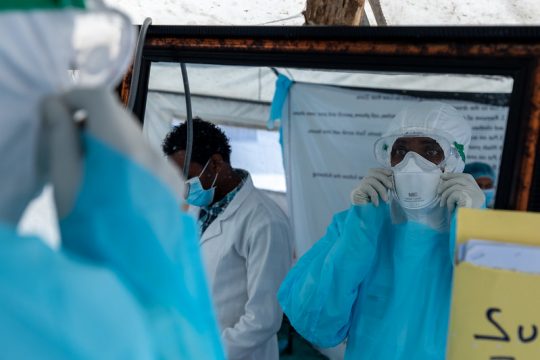 Les agents de santé inspectent leur équipement de protection individuelle avant d'interagir avec un patient suspecté d'avoir le COVID-19