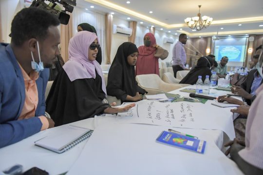 Des femmes et des hommes autour d'une table de réunion / Crédit photo : AMISOM / CC / Iwaria.com