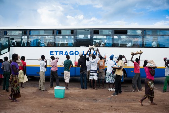 Une masse des vendeurs ambulants au tour d'un bus de voyage