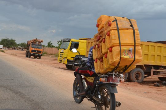 Un motocycliste transportant des bidons remplis d'essence passés en contrebande du Nigéria à la ville de Maradi - Crédit : BOUREIMA HAMA / AFP