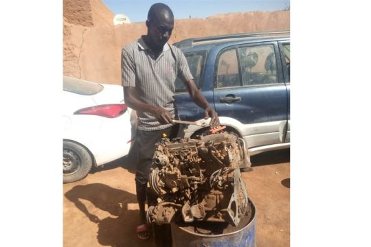 Ousseini dans son atelier de mécanique auto