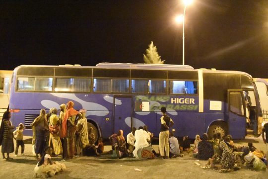 Des migrants nigériens en train de monter dans un bus