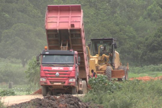 Un camion déverse de la latérite sur la digue principale pour prévenir d'éventuelle inondation