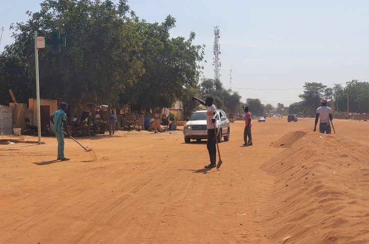 Des jeunes déblaient les rues sablonneuses de Niamey