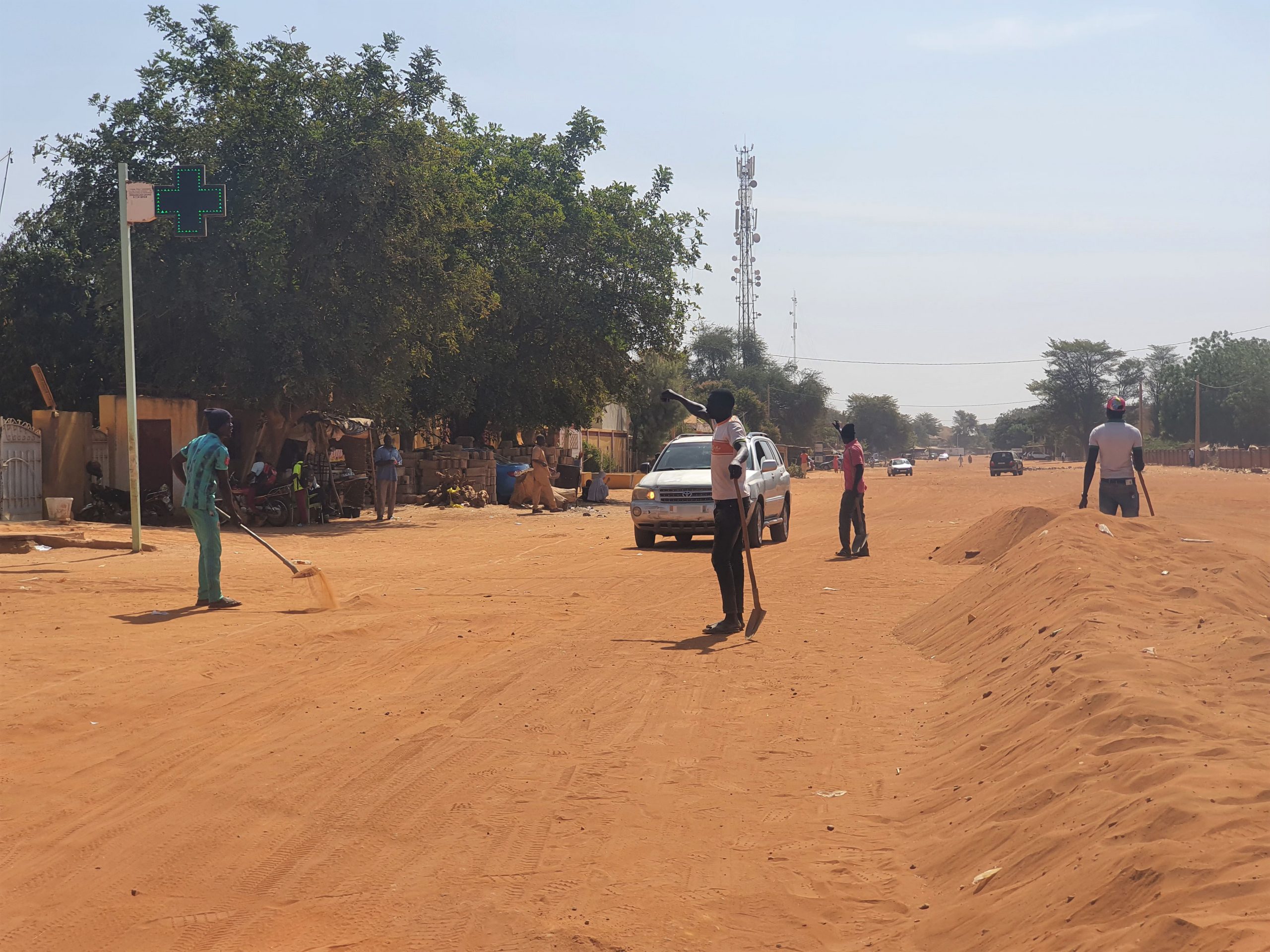 Des jeunes déblaient les rues sablonneuses de Niamey