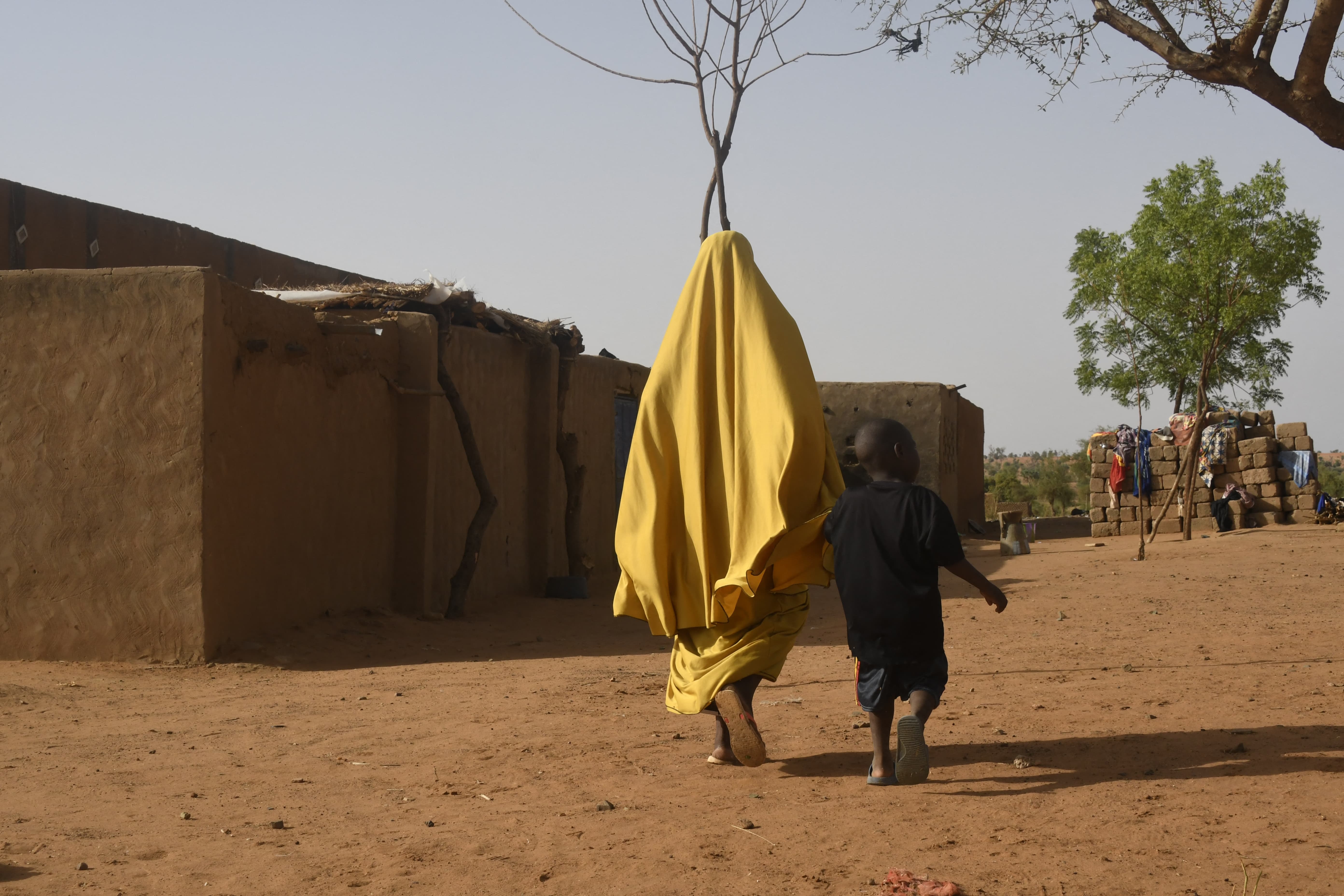 Une femme et son enfant marchent dans le village de Garbey Kourou, au sud-ouest du Niger, le 9 juin 2022 - BOUREIMA HAMA / AFP