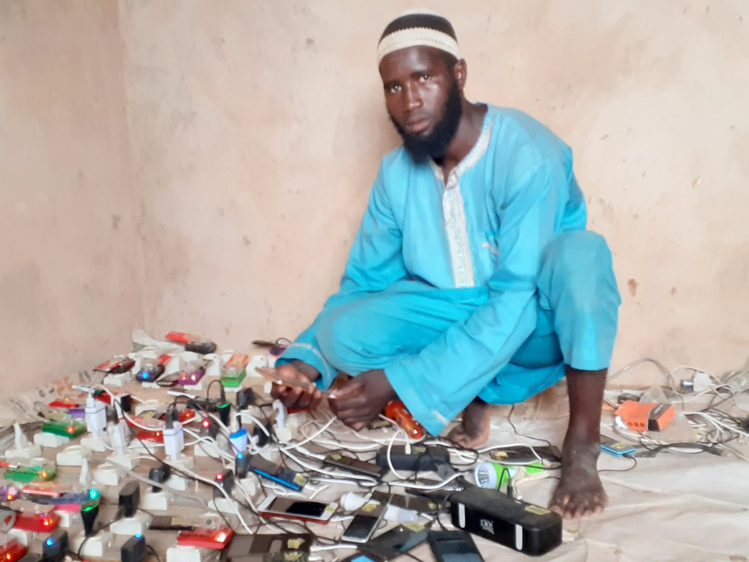 Portrait d’un ancien conducteur de taxi-moto reconverti à charger les téléphones portables, dans le marché de Balleyara